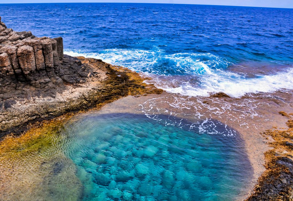 A high angle shot of a beautiful sea surrounded by rock formations in the Canary Islands, Spain
